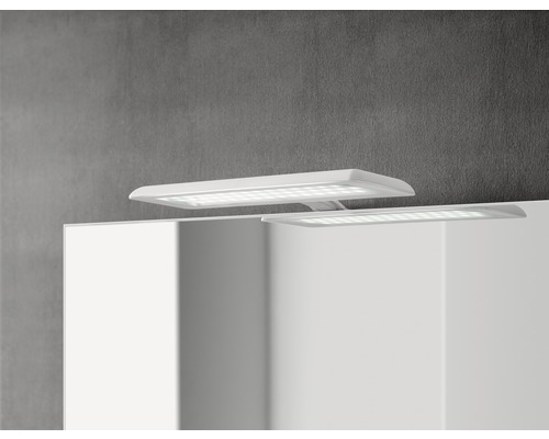 Auf einem Badezimmerspiegel sind zwei LED-Aufsatzleuchten montiert.