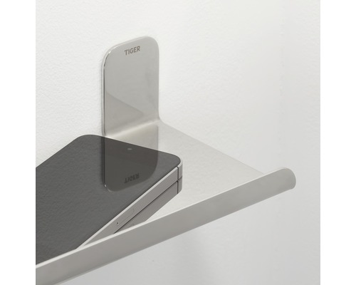 Tiger Logo auf einem Ablagebord aus Metall mit einem Smartphone