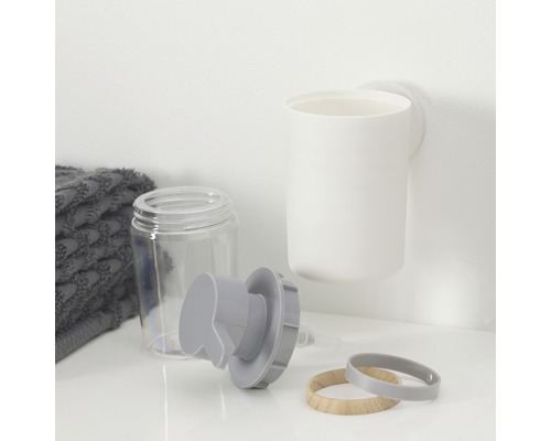 Seifenspender, Zahnputzbecher und Handtuch auf einer Ablage