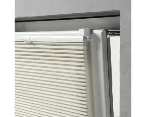 Nahaufnahme einer beigen Plisseejalousie am Fenster