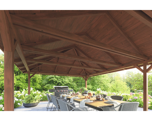 Überdachter Sitzbereich mit Esstisch und Grill im Garten