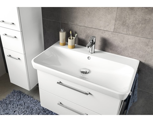 Weißer Waschtischunterschrank mit Waschbecken, Armatur und Handtuchhalter im Badezimmer