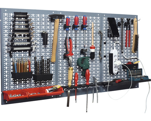 Werkzeugwand mit verschiedenen Werkzeugen wie Hammer, Schraubenschlüssel, Schraubenzieher und Bohrer.