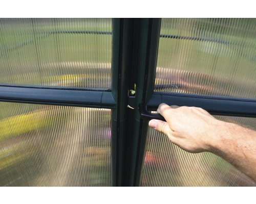 Detailansicht eines Gewächshauses mit Hand am Türgriff