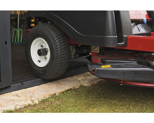 Aufsitzrasenmäher fährt über eine Gummimatte in eine Garage