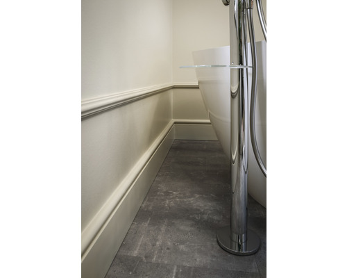 Detailansicht eines Badezimmers mit einer freistehenden Badewanne, Wandverkleidung und Bodenfliesen.