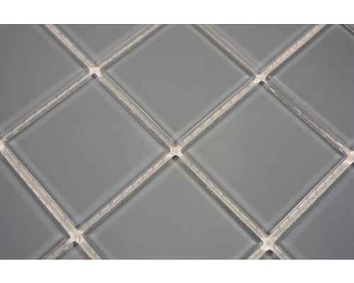 Nahaufnahme von grauen Mosaikfliesen in Rautenform.