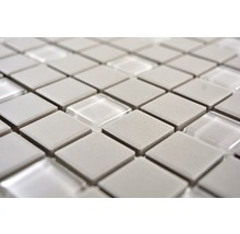 Nahaufnahme von Mosaikfliesen mit quadratischen grauen Steinen und transparenten Glaselementen