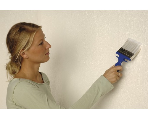 Frau streicht Wand mit einem Flächenstreicher