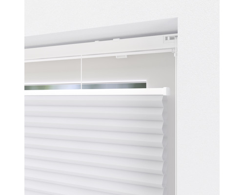 Detailansicht eines weißen Plissees am Fenster