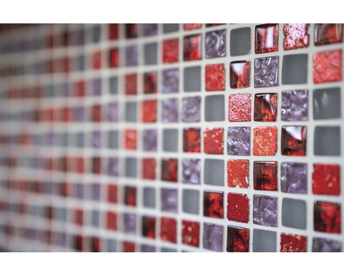 Nahaufnahme einer Wand mit roten, violetten und grauen Mosaikfliesen