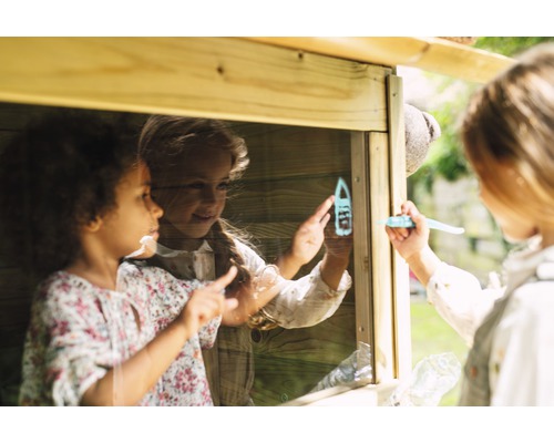 Drei spielende Kinder in einem Holzspielhaus mit Fenstern