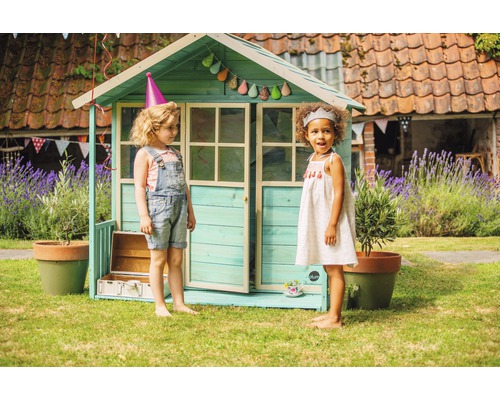 Spielhaus mit zwei Kindern im Garten. Dekoration mit Girlande und Partyhüten.