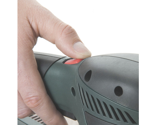 Nahaufnahme einer Hand, die einen roten Knopf an einem Elektrowerkzeug drückt.