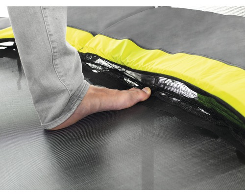 Detailaufnahme eines Fußes auf einem Trampolin mit Sicherheitsnetz