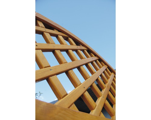 Nahaufnahme eines hölzernen Spalierbogens vor blauem Himmel