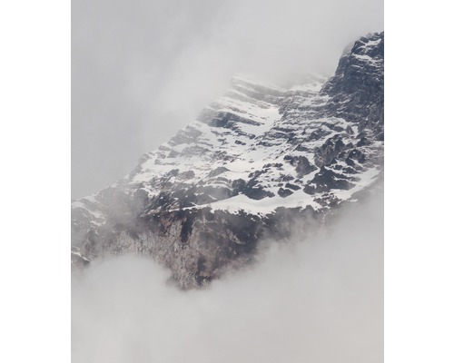 Berglandschaft mit Felsen und Schnee in Wolken gehüllt