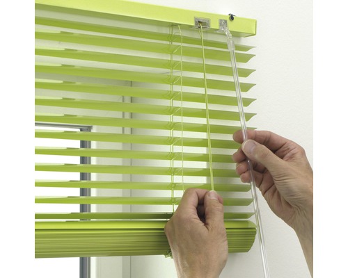 Grüne Jalousie mit Bedienung durch eine Person