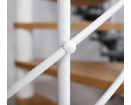 Detailaufnahme eines weißen Treppengeländers mit Holzstufen im Hintergrund