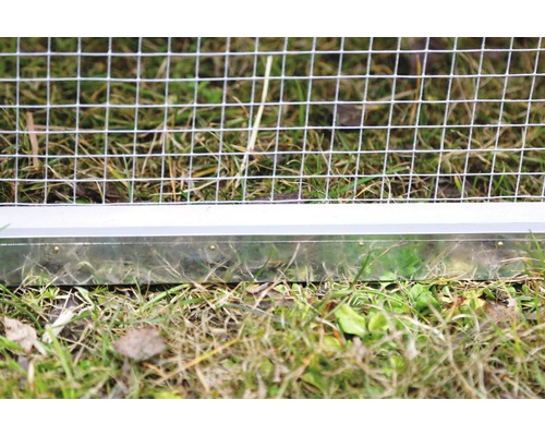 Detailansicht eines Drahtzauns mit Metallsockel auf Gras