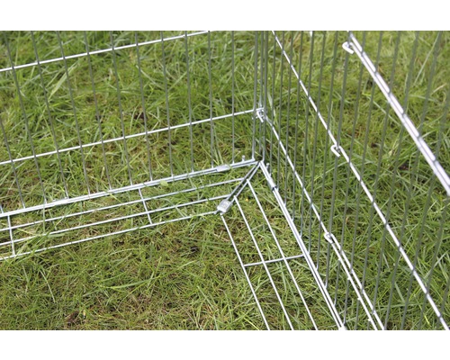 Detailansicht eines Hundeauslaufs aus Metall auf einer Wiese