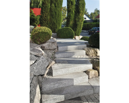 Außentreppe aus Granit mit seitlicher Steinmauer und Bepflanzung