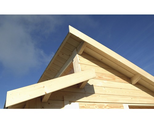 Detailansicht eines Holzhauses mit Giebeldachkonstruktion vor blauem Himmel
