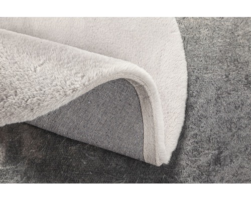 Detailansicht eines hellen Teppichs mit Textilrücken