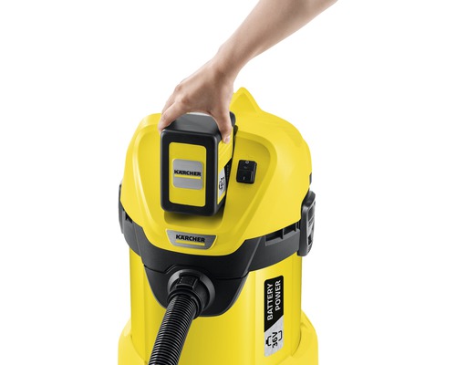 Eine Hand setzt einen Akku in einen gelben Kärcher Staubsauger ein.