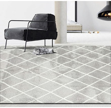 Grauer Teppich mit Rautenmuster in einem Wohnzimmer mit Sessel und Kamin.