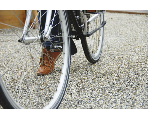 Nahaufnahme eines Fahrrads mit Person auf Kiesuntergrund