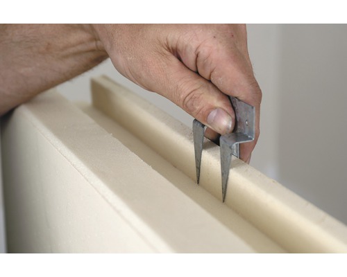 Eine Person verwendet ein Schneidwerkzeug für Dämmstoffe.