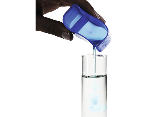 Eine Flüssigkeit wird mit einem blauen Messbecher in ein Reagenzglas gegossen.