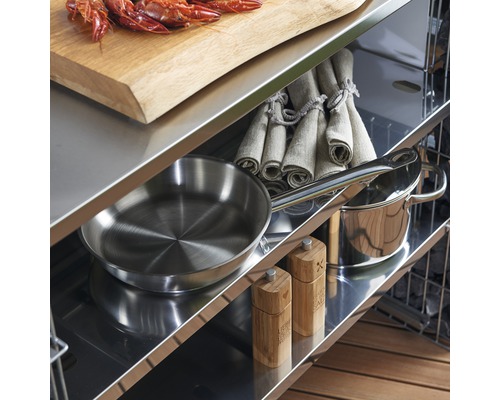 Regale einer Outdoorküche mit Kochutensilien, Geschirrtüchern, Gewürzmühlen und Krustentieren auf einem Schneidebrett