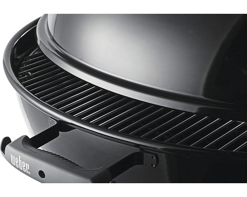 Detailansicht eines Holzkohlegrills mit Grillrost und Deckel.