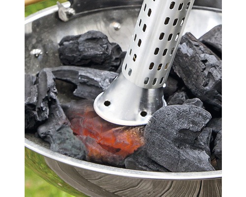 Grillanzünder mit glühenden Holzkohlebriketts in einem Holzkohlegrill