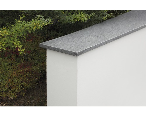 Eine Mauerabdeckung aus Stein auf einer weißen Mauer