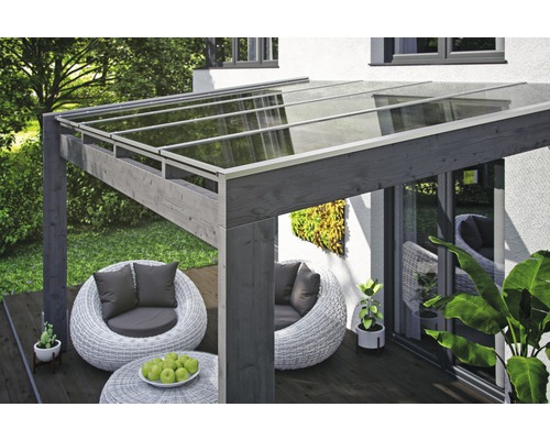 Terrassenüberdachung aus Holz mit Glasdach und Sitzgruppe im Garten.