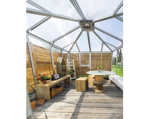 Gewächshaus mit Holzmöbeln und Pflanzendekoration auf Holzterrasse