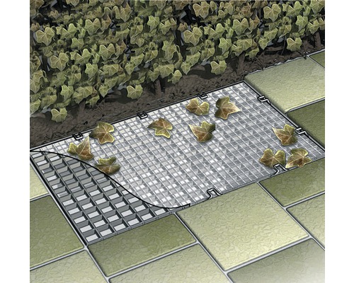 Abdeckung eines Entwässerungssystems mit Laub auf Pflastersteinen