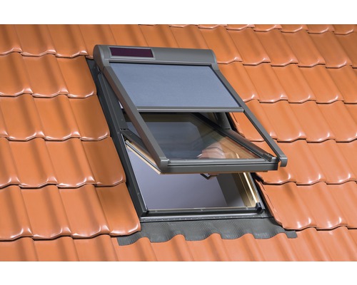 Geöffnetes Dachfenster mit Sonnenschutz auf einem Ziegeldach