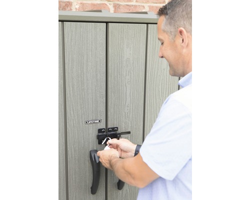 Mann schliesst einen Geräteschuppen ab