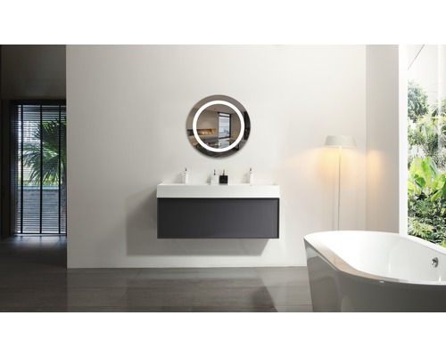 Modernes Badezimmer mit Waschtisch, rundem Spiegel mit Beleuchtung und Badewanne