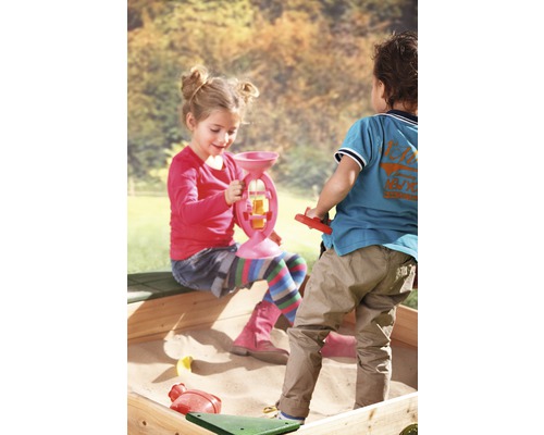 Kinder spielen mit Sandspielzeug in einem Sandkasten.