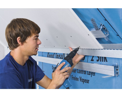 Handwerker befestigt eine Gipskartonplatte mit einem Akku-Schrauber an einer Unterkonstruktion.