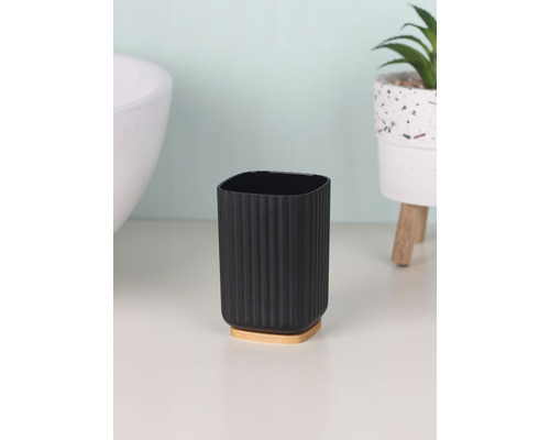 Zahnputzbecher aus Kunststoff mit Holzfuß im Badezimmer