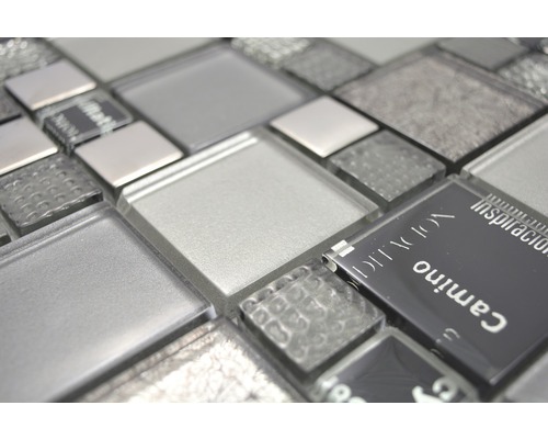 Nahaufnahme von Glasmosaikfliesen in verschiedenen Grautönen und Texturen.