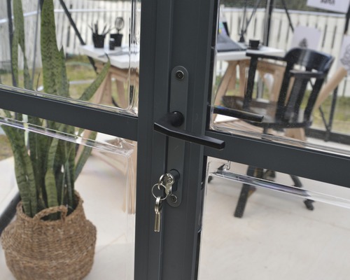 Detailaufnahme einer abschließbaren Gewächshaustür mit Schlüssel
