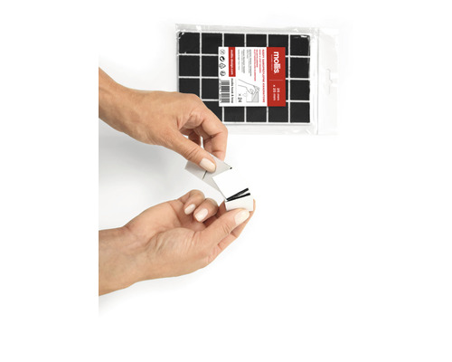 Quadratische, selbstklebende Pads, 20 mal 20 Millimeter, in einer Verpackung mit 24 Stück. Eine Person entfernt die Schutzfolie von einem Pad.