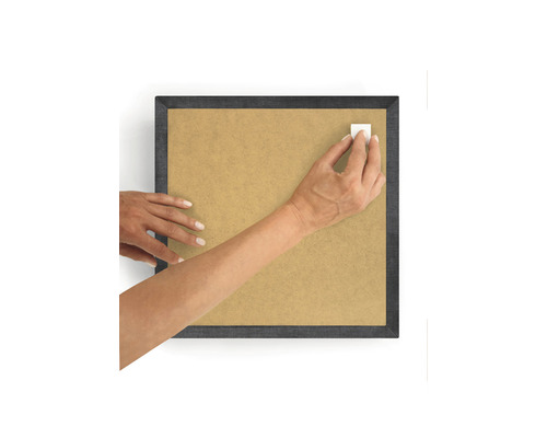 Person befestigt einen Klebestreifen an einem Bilderrahmen.